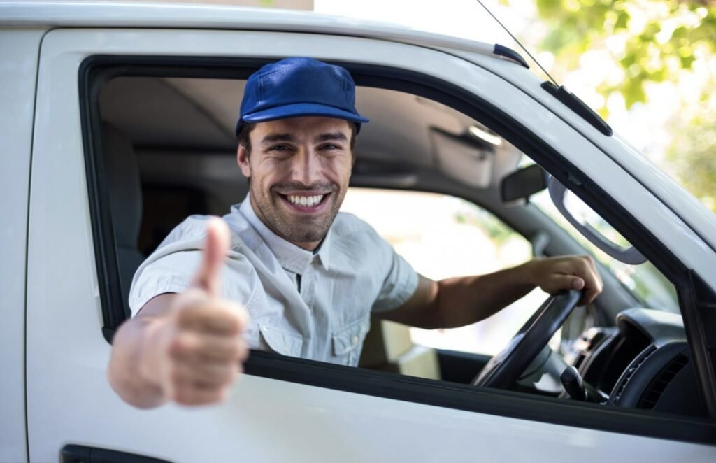 Technicien assainissement souriant au volant, prêt pour intervention rapide et courtoise en Essonne