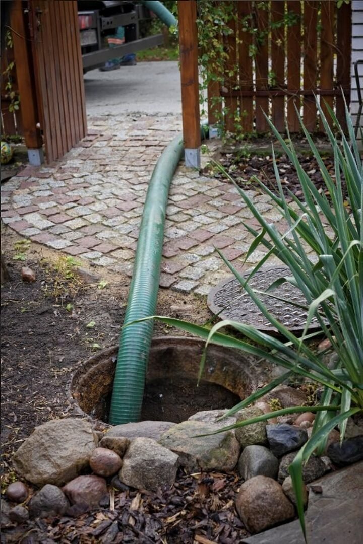 Pompage fosse septique Essonne (91) – tuyau d’aspiration en intervention dans un jardin